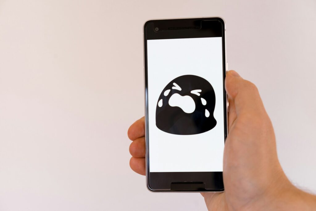 a hand holding a cell phone with a skull on it