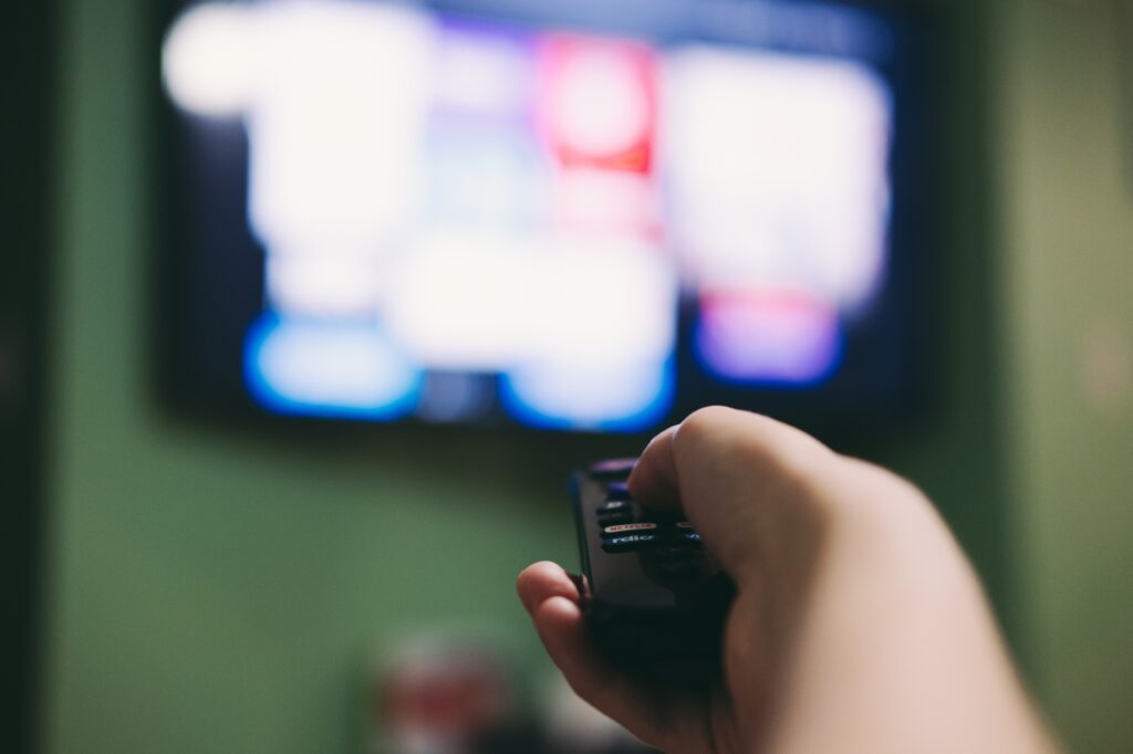 Woman using remote to search for movies on the television