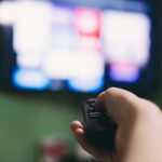 Débits Netflix sur Free : Comment désactiver l'IPv6 pour résoudre les problèmes Woman using remote to search for movies on the television