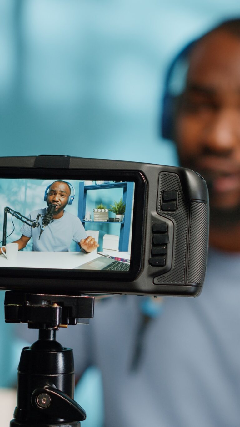 Close up of camera screen recording blogger with headphones