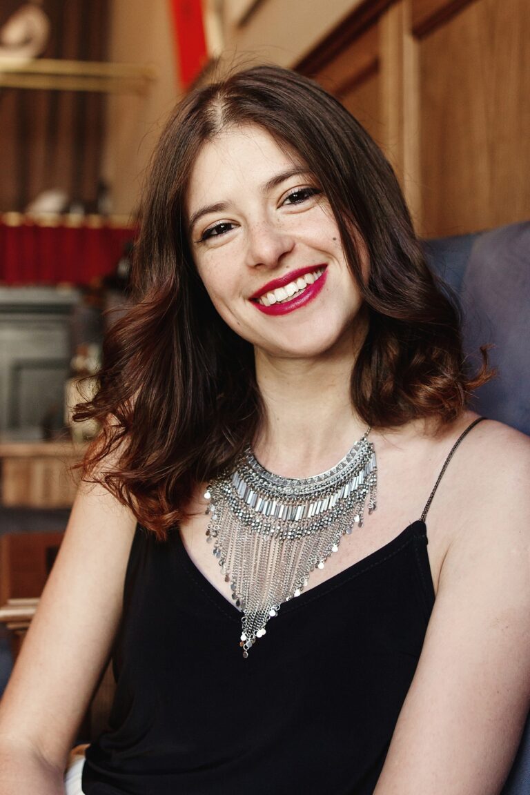 stylish happy woman sitting at rich restaurant, smiling, space for text