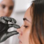 Woman in a cosmetic surgery clinic examining her nose