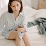 Guide étape par étape pour débloquer et désimlocker un iPhone Bouygues Telecom, SFR ou Orange woman on bed using blue iphone 13pro, technologies, morning routine, working from home