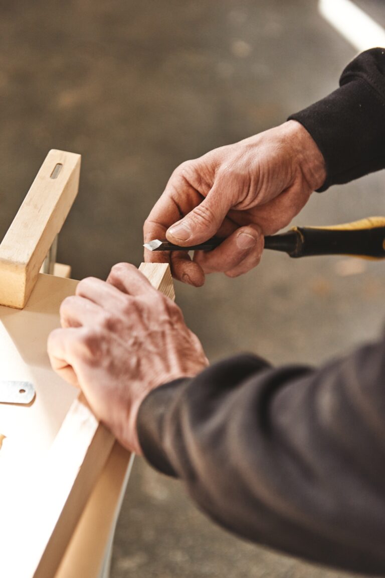 Custom woodworking and carpentry. Close up of a carpenter's hands holding wooden plank and