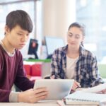 Pc portable, fixe ou tablette : quelle option choisir pour un ado ? Young man using tablet pc in study