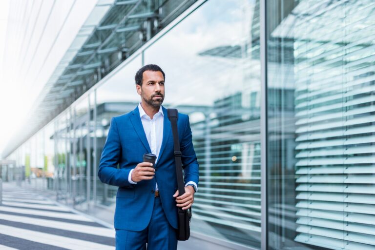 Businessman with coffee to go and laptop bag