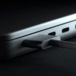 MagSafe 3 power adapter connecting to new laptop. Charger for laptop close-up. Metal silver version