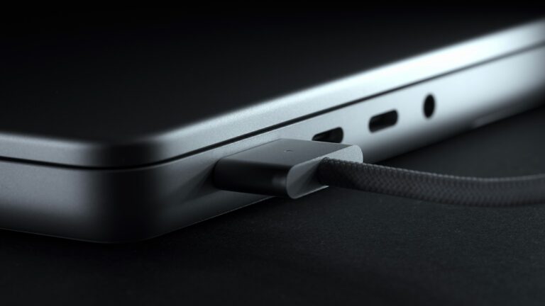 MagSafe 3 power adapter connecting to new laptop. Charger for laptop close-up. Metal silver version