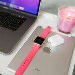 Les AirPods en promo post-Nouvel An : jusqu'à 99 € d'économies qui changent la donne A neatly arranged desk with a laptop, iPad, smartwatch, AirPods, and candle.