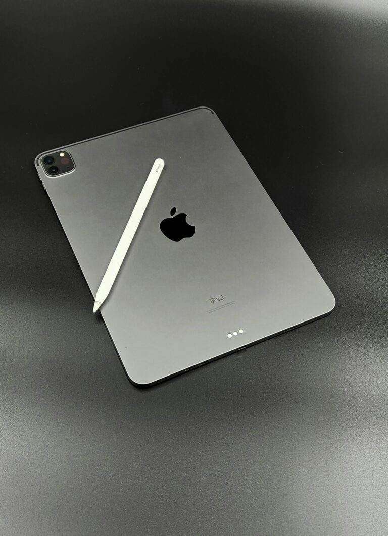 Apple iPad with Apple Pencil on a sleek black surface, showcasing minimalist design.