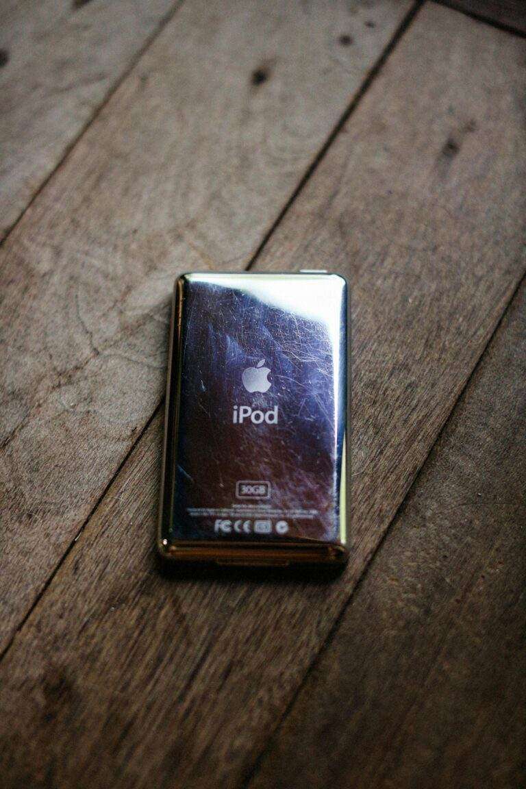 Nouvelle panne pour Apple Music : les utilisateurs font face à une seconde vague d’interruptions après de récents dysfonctionnements majeurs Classic iPod 30GB with a reflective surface on a rustic wooden floor.