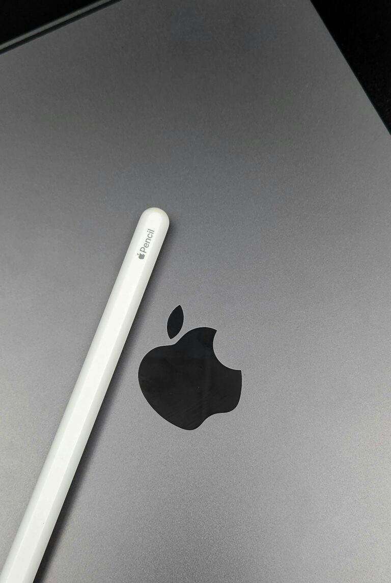 Close-up image of an Apple Pencil resting on a MacBook surface, showcasing technology accessories.