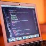 Apple Lève le Voile sur les Premières Bêta d'iOS 26.1, d'iPadOS 26.1 et de macOS Tahoe 26.1 Focused shot of a laptop displaying code, suitable for tech and coding themes.