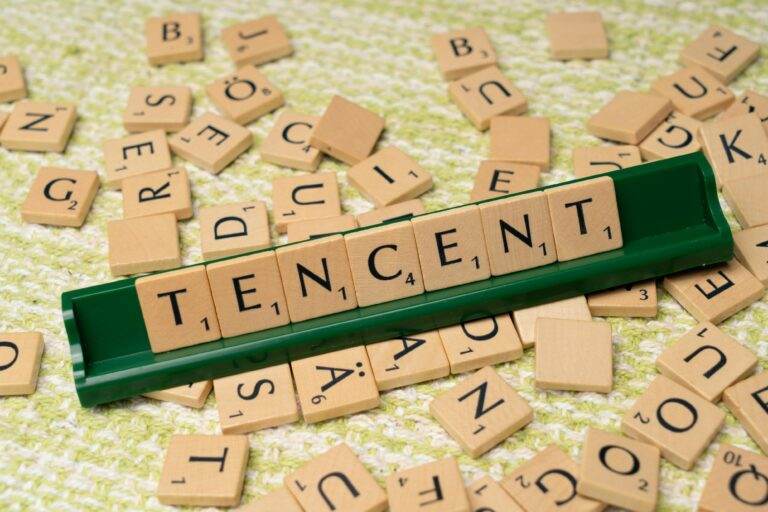 Apple et Tencent concluent un accord autour d’une commission de 15% sur les achats des mini-jeux WeChat Wooden Scrabble tiles arranged to spell 'Tencent' on a green tile holder, scattered letters in the background.