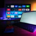 tvOS 26.2 : Créez des profils Apple TV sans compte et profitez d'un mode enfants dédié A modern home setup with a smart TV and tablet displaying various streaming apps, highlighting the digital lifestyle.