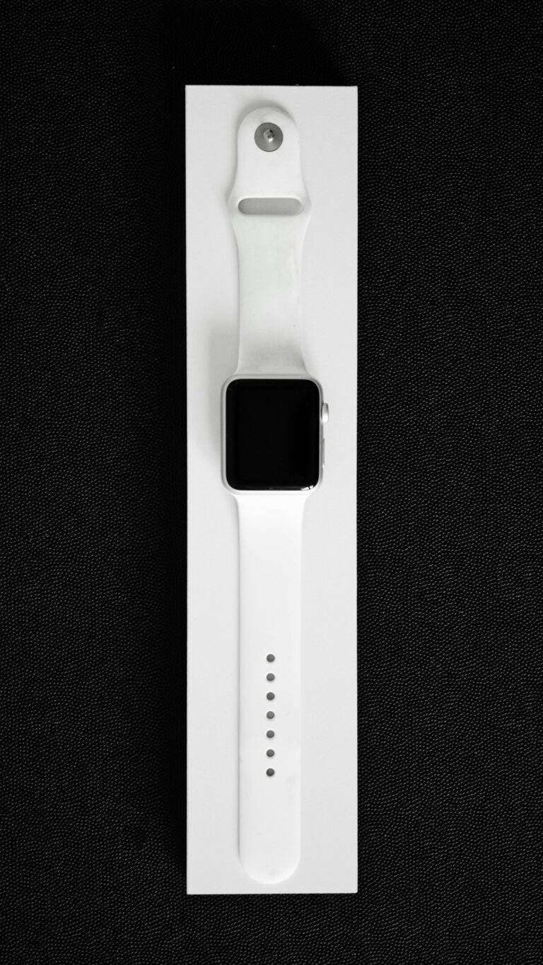 White smartwatch showcased in a minimalist style on black background, emphasizing modern design.