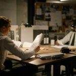 Trump envisage une enquête commerciale après les amendes 'discriminatoires' infligées par l'UE à Google et Apple Two detectives analyzing documents in an office setting under dim lighting, focusing on investigation.