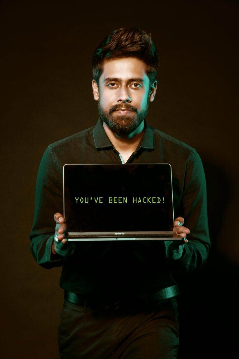 Apple et Google lancent une nouvelle vague d’alertes mondiales sur les cybermenaces pour protéger leurs utilisateurs A man showing a laptop with a 'You've been hacked' message, symbolizing cyber security threats.