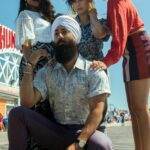 Duolingo transforme la Dynamic Island en panneau publicitaire et s'attire les foudres d'Apple A stylish mixed-gender group posing on a sunny boardwalk, showcasing casual summer fashion.