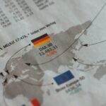 From above of business newspaper with trading indexes and flags of Germany France and European Union