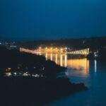 Beautiful night view of a suspension bridge over the Ganges River in Rishikesh, India, illuminated by lights.