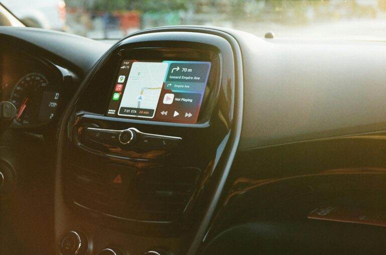 Inside view of a car showing a GPS navigation system on the dashboard in daylight.