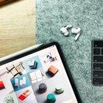 Flat lay of an iPad, AirPods Pro, and keyboard for a tech-savvy workspace setup.
