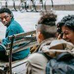 Vous avez raté l'iPhone 17 Pro ? Découvrez les rumeurs fascinantes sur l'iPhone 18 Pro ! A diverse group of young adults engage in conversation on a street bench.