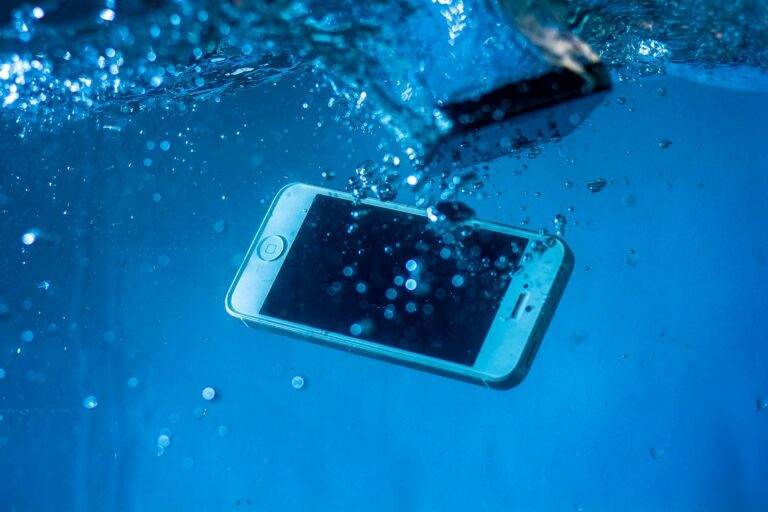 A smartphone immersed underwater amidst bubbles, creating a dynamic visual effect.