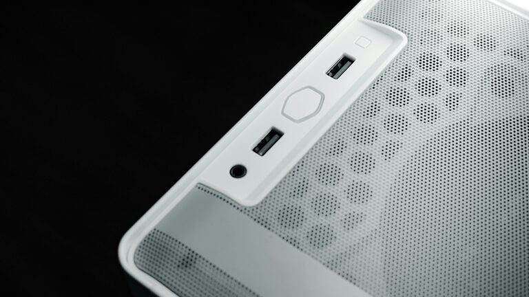 Detailed view of USB and audio ports on a white computer case, showcasing modern technology design.