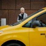 Alors que les talents clés quittent Apple, découvrez la nouvelle génération de leaders qui défie l'ancienne garde Confident businesswoman stands by a New York City yellow taxi, epitomizing urban professionalism.