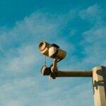 La technologie Passkey d'Apple révolutionne la sécurité des Mac grâce à l'authentification biométrique et au stockage chiffré A surveillance camera mounted outdoors against a bright blue sky, symbolizing security and monitoring.