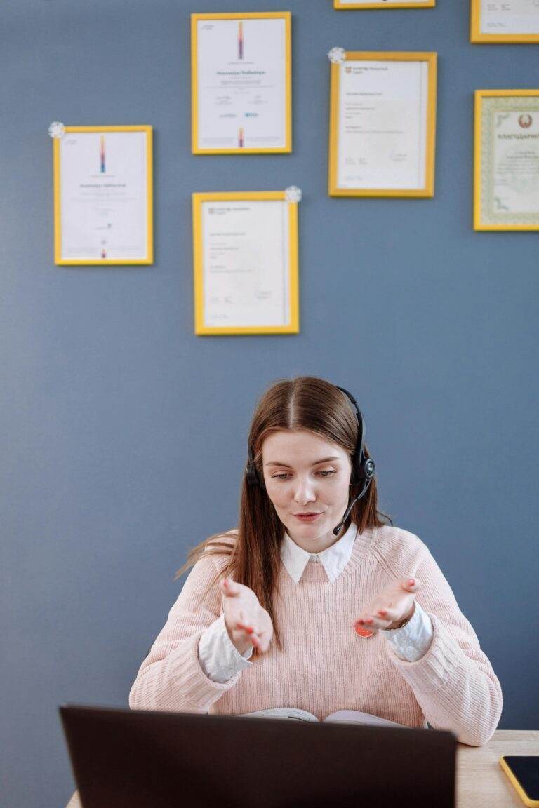 Apple mise tout sur l’IA pour forcer le renouvellement des iPhone A woman wearing a headset having an online meeting, with certificates framed on the wall behind.