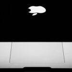 Intel dans l'iPhone : la rumeur qui redessine toutes les certitudes d'Apple Elegant close-up of a MacBook featuring the iconic Apple logo on a black background.