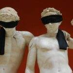 La Russie coupe Snapchat et FaceTime : quand la censure frappe l'iPhone Two marble statues blindfolded, symbolizing protest against censorship, art on orange background.