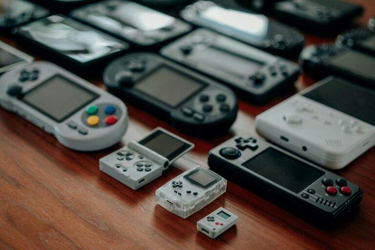 Collection of diverse retro handheld gaming consoles on a wooden surface, showcasing classic designs and nostalgia.
