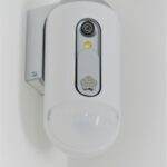 Close-up view of a contemporary indoor surveillance camera mounted on a wall for security monitoring.