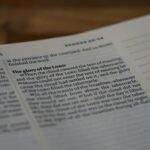 A focused close-up of a Bible page highlighting Exodus 40:34, depicting profound religious themes.