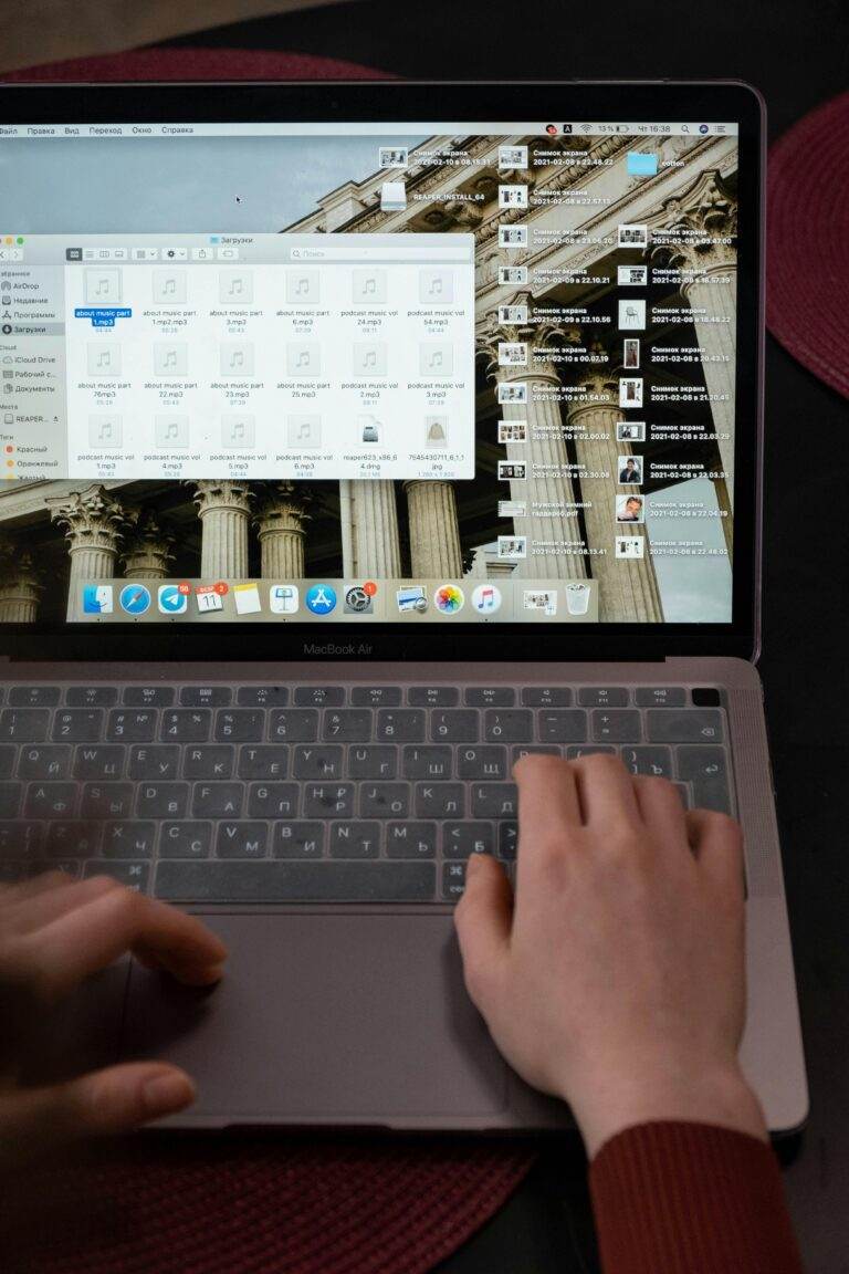 Close-up of hands typing on a MacBook laptop indoors, perfect for technology or digital lifestyle themes.