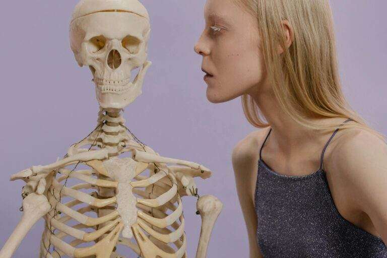 Comment supprimer totalement son profil et compte Tinder ? An artistic portrayal of a woman and skeleton against a purple background.