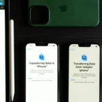 Two smartphones transferring data, showcasing modern mobile technology on a dark desk.