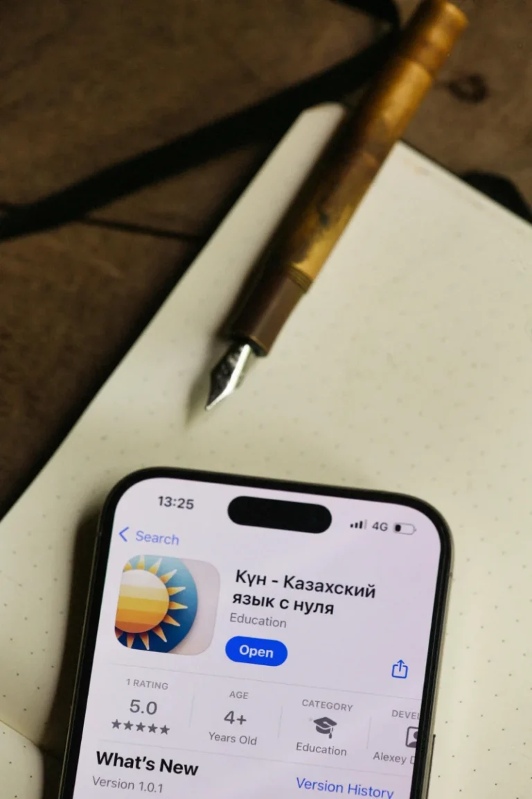 Close-up of a smartphone displaying an educational app in Russian on a table.