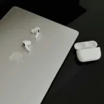 Rétrospective Apple : chocolat Apple Music, nouveaux appareils en préparation, fabrication américaine Top view of hands arranging an iPad, iPhones, and earphones on a white surface. Perfect for tech-related imagery.