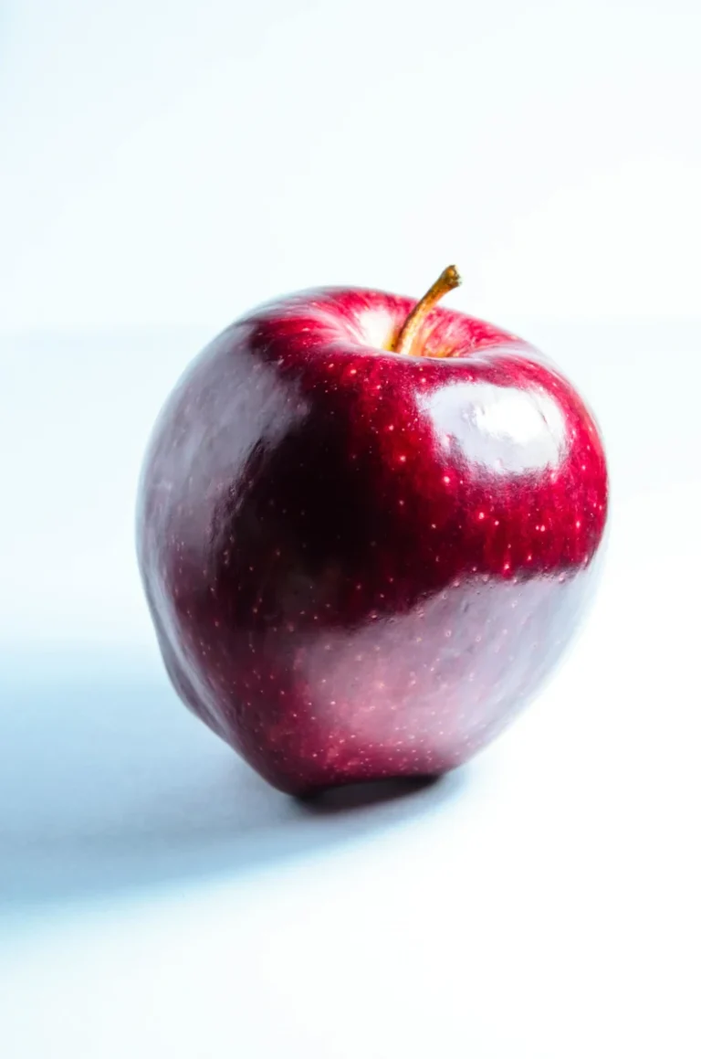 High-quality image of a fresh, shiny red apple with a white background.