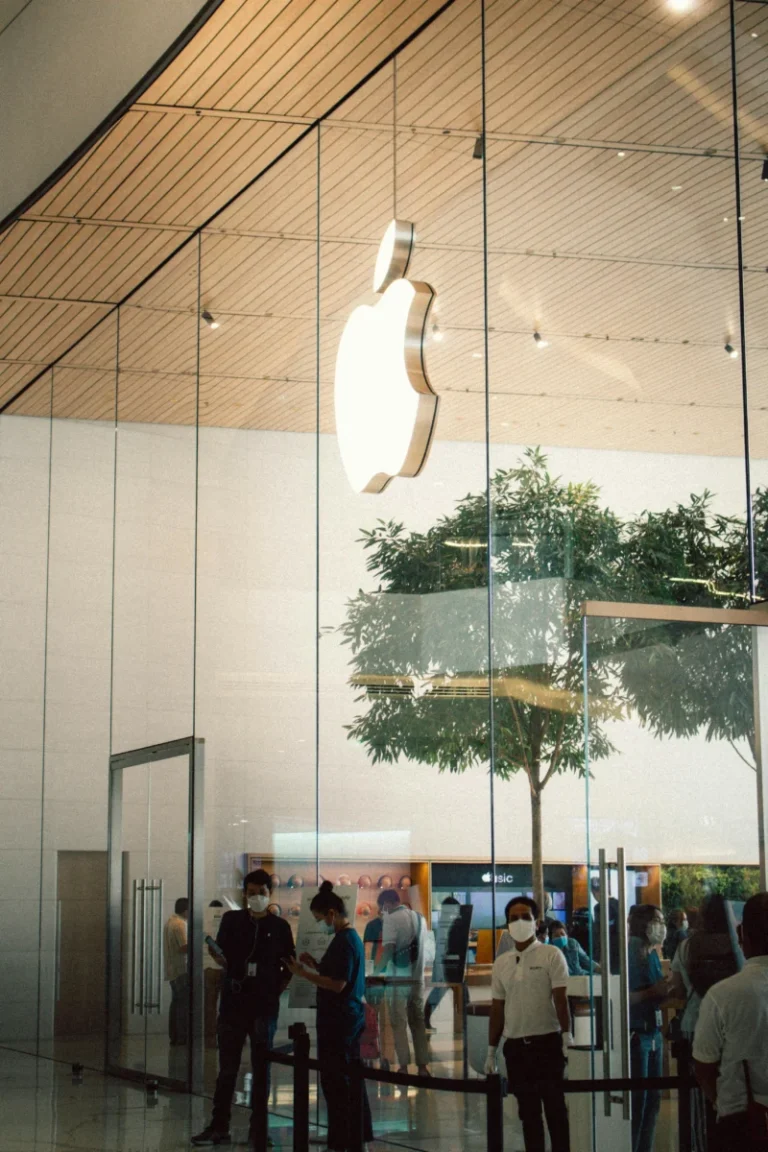 Apple Store entrance in Bangkok with people and glass architecture visible.