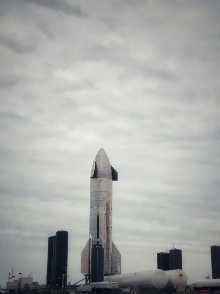 A space shuttle is ready for launch against a cloudy sky on a launch pad.