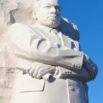 Apple Martin dévoile ses projets après l'université et renonce à la faculté de droit Stone statue of Martin Luther King Jr. against a clear blue sky at the Washington DC memorial.
