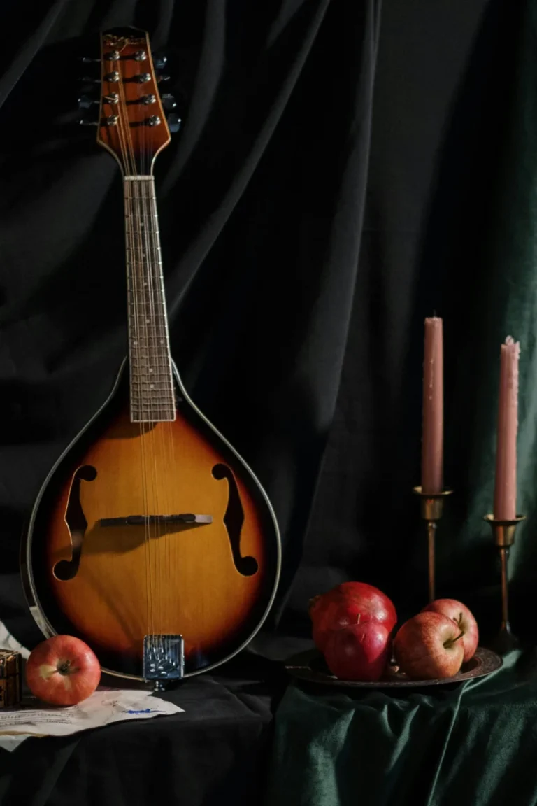 A classic setup of a vintage mandolin surrounded by apples and candles. Perfect still life.