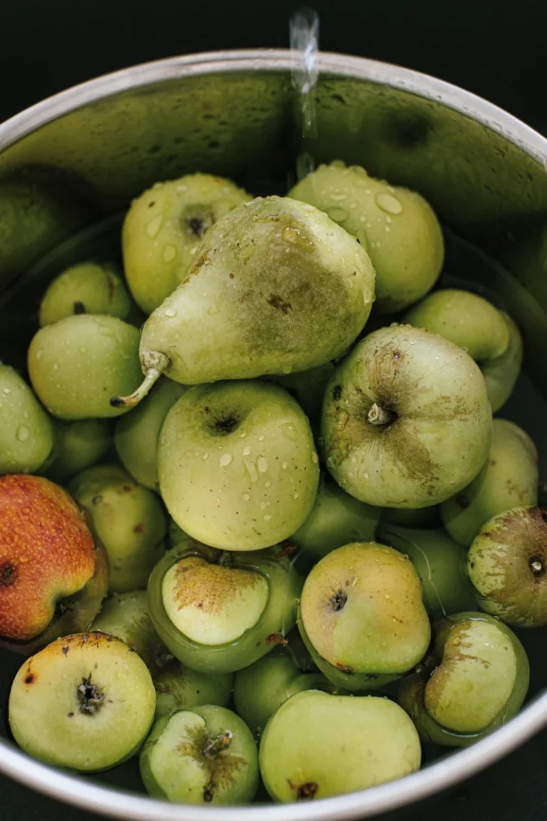 Close-up of fresh green apples and pears in a bowl of water, showcasing natural freshness.