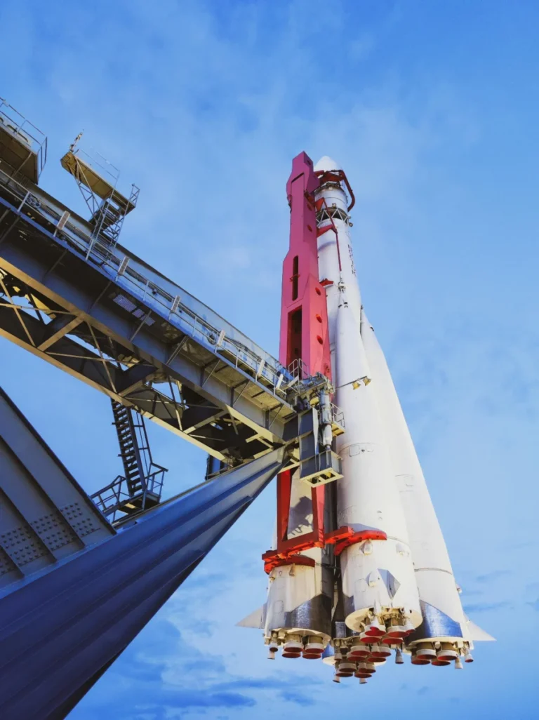 Low angle view of a space rocket at launch pad, showcasing modern aerospace engineering against a bright blue sky.